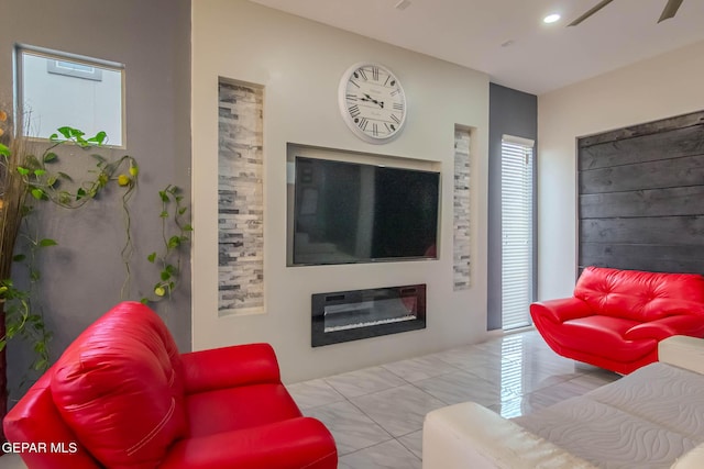 living area with a glass covered fireplace and recessed lighting