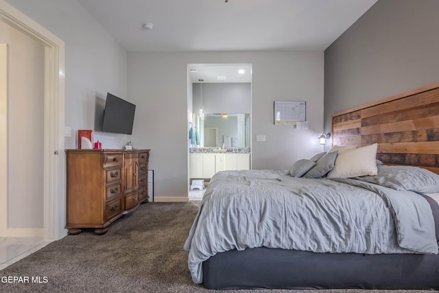 bedroom with dark carpet and connected bathroom