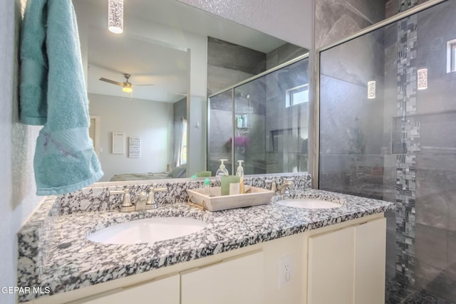 bathroom featuring ceiling fan, a stall shower, a sink, and double vanity