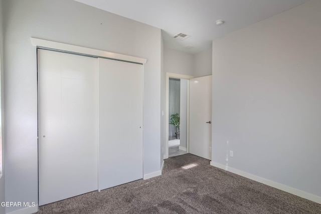 unfurnished bedroom featuring carpet floors, baseboards, visible vents, and a closet