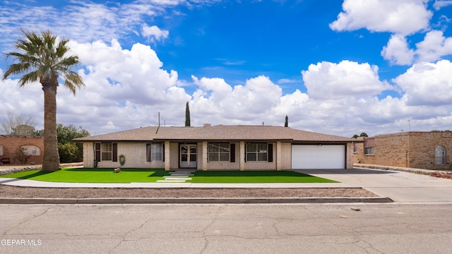 view of front of property featuring a garage, concrete driveway, roof with shingles, a front yard, and brick siding