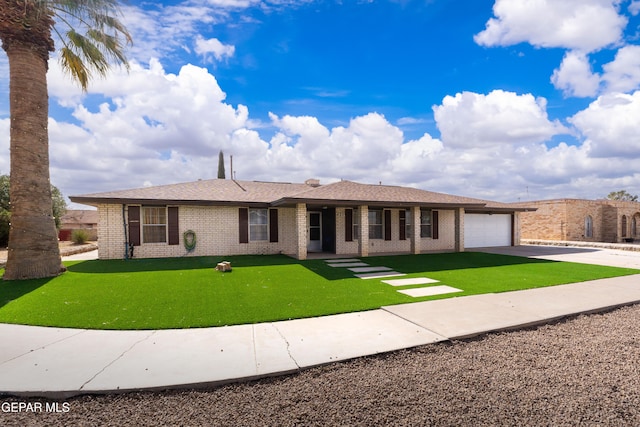 view of front of home with a garage, brick siding, driveway, and a front yard