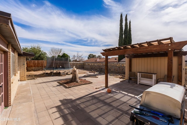 view of patio featuring a trampoline, a fenced backyard, grilling area, and a pergola