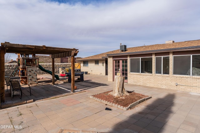 view of patio with a playground, cooling unit, and french doors