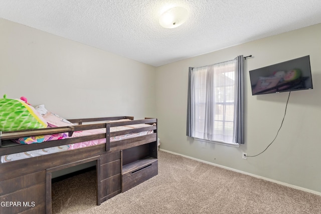 bedroom with a textured ceiling, carpet flooring, and baseboards