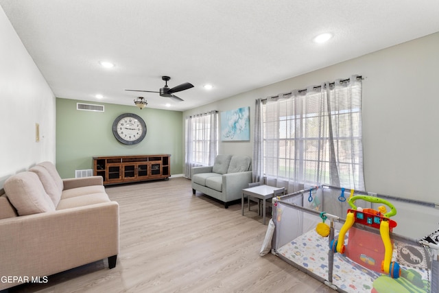 living room with a ceiling fan, wood finished floors, visible vents, and recessed lighting