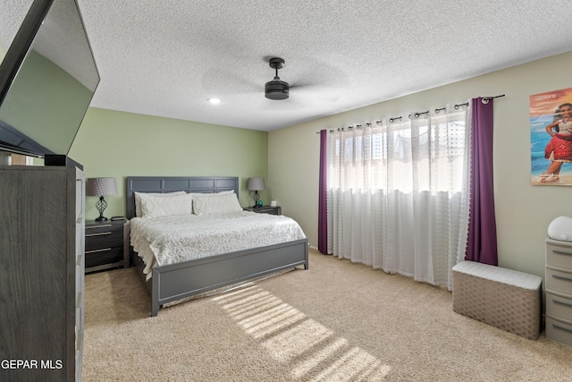 bedroom featuring a textured ceiling, carpet flooring, and a ceiling fan