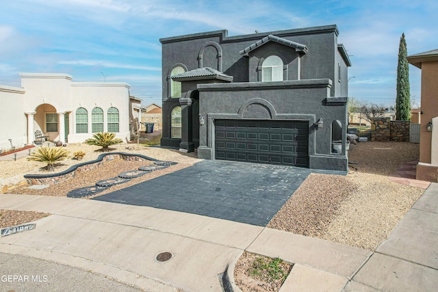 view of front facade with aphalt driveway, an attached garage, and stucco siding