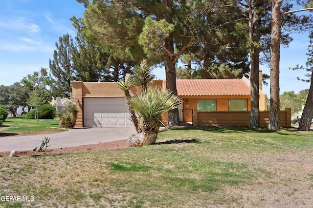 view of front facade featuring concrete driveway, a tile roof, a chimney, an attached garage, and a front lawn