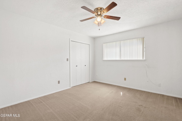 spare room with baseboards, a textured ceiling, a ceiling fan, and carpet flooring