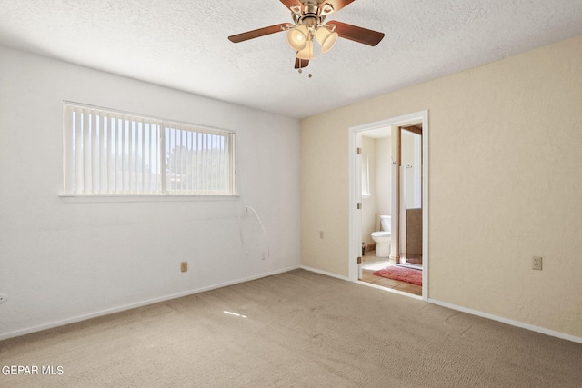 spare room featuring a textured ceiling, ceiling fan, carpet, and baseboards