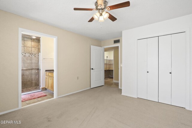 unfurnished bedroom featuring a closet, light carpet, connected bathroom, and visible vents