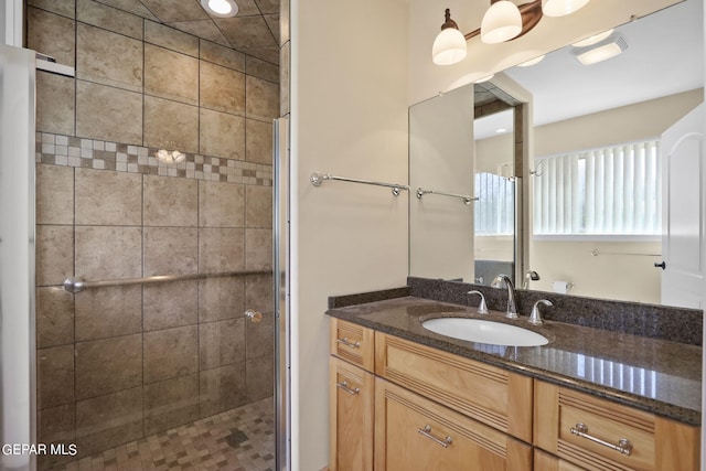 full bath with a stall shower and vanity