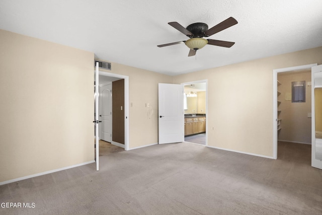 unfurnished bedroom featuring baseboards, visible vents, a ceiling fan, light colored carpet, and ensuite bathroom