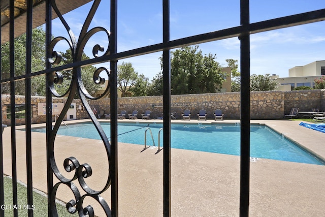 community pool with fence and a patio