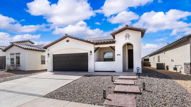 mediterranean / spanish-style house with a garage, cooling unit, concrete driveway, and stucco siding