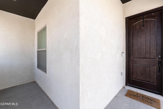 doorway to property featuring stucco siding