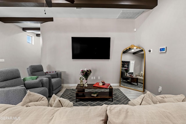 living room with visible vents, beamed ceiling, baseboards, and wood finished floors