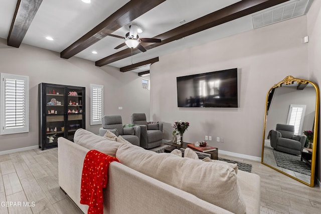 living room featuring light wood-style floors, visible vents, and beam ceiling