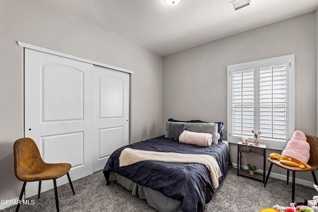 bedroom with a closet, carpet flooring, visible vents, and baseboards