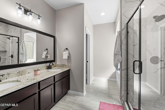 bathroom featuring double vanity, a shower stall, and a sink