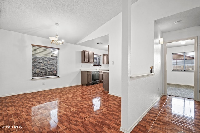 interior space with lofted ceiling, an inviting chandelier, baseboards, and a textured ceiling