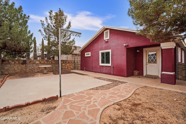 exterior space with a patio area, fence, and stucco siding