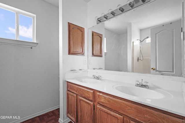 full bath featuring double vanity, a sink, and baseboards