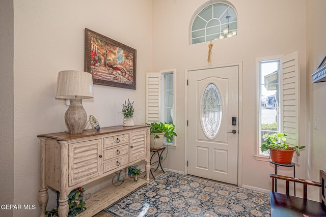 entryway with a towering ceiling and baseboards