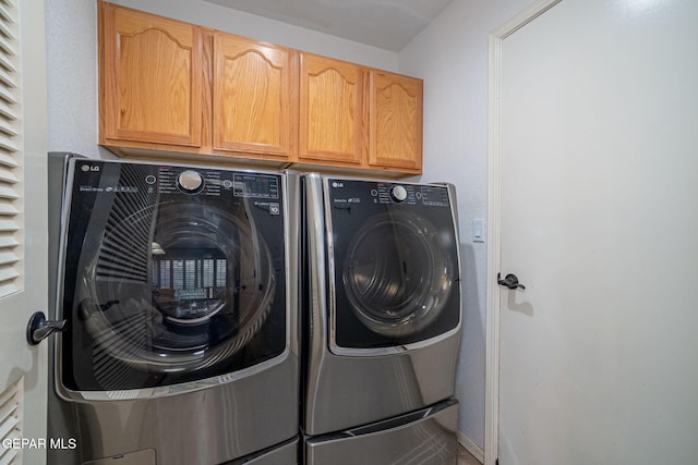 clothes washing area featuring cabinet space and washing machine and clothes dryer