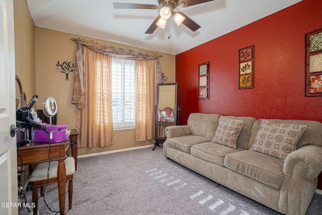 carpeted living area featuring ceiling fan, baseboards, and a textured wall