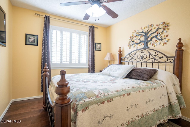 bedroom featuring ceiling fan, a textured ceiling, baseboards, and wood finished floors