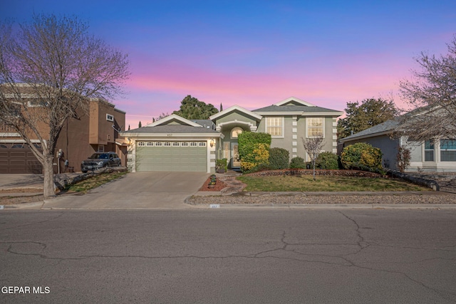 view of front of property featuring concrete driveway, an attached garage, and stucco siding