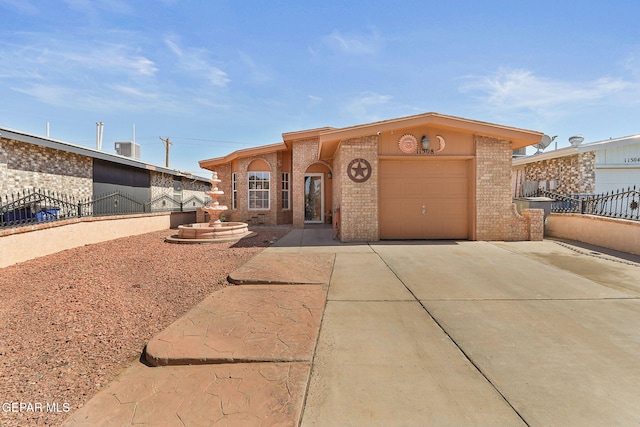 view of front of property with an attached garage, cooling unit, brick siding, fence, and concrete driveway