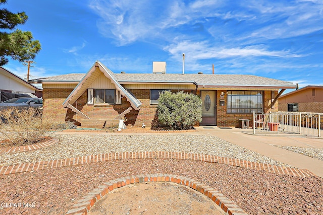 view of front of property with brick siding and roof with shingles