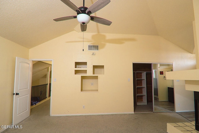 interior space with carpet, visible vents, vaulted ceiling, and a textured ceiling