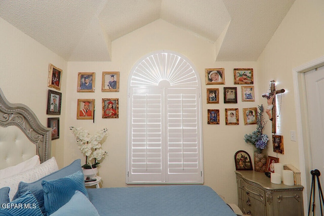 bedroom with vaulted ceiling and a textured ceiling