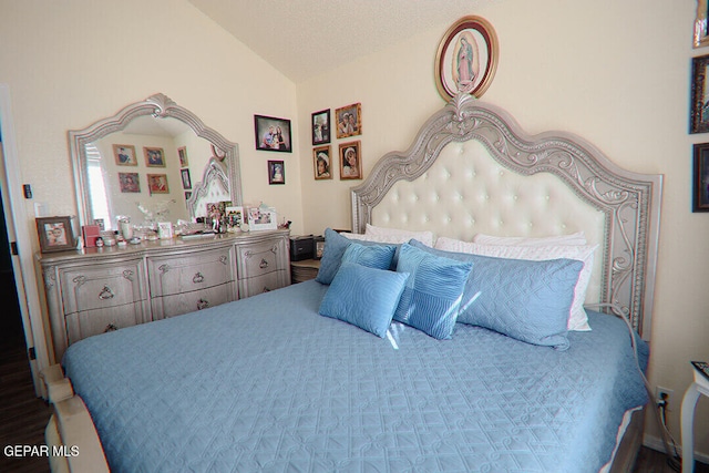 bedroom with lofted ceiling and a textured ceiling