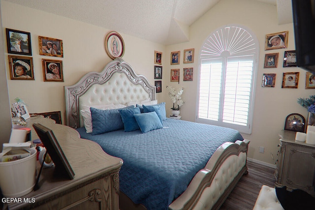 bedroom featuring lofted ceiling, a textured ceiling, baseboards, and dark wood-style flooring