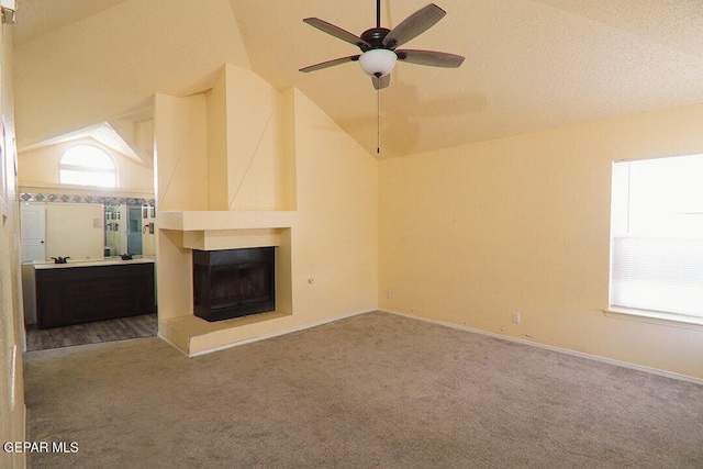 unfurnished living room with carpet flooring, a multi sided fireplace, a ceiling fan, vaulted ceiling, and baseboards