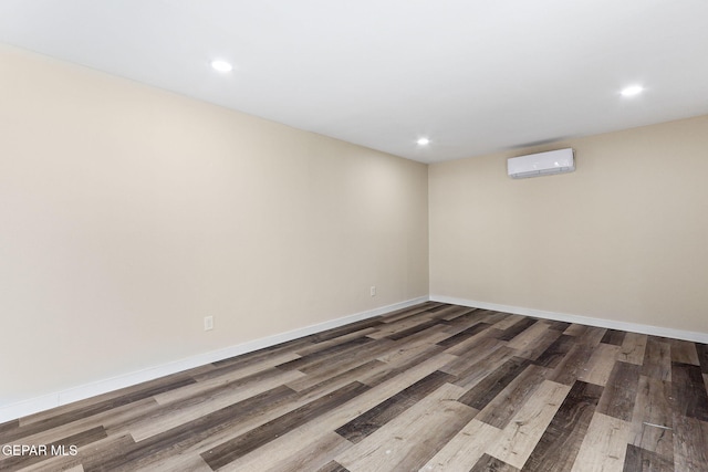 finished basement with a wall mounted AC, recessed lighting, wood finished floors, and baseboards