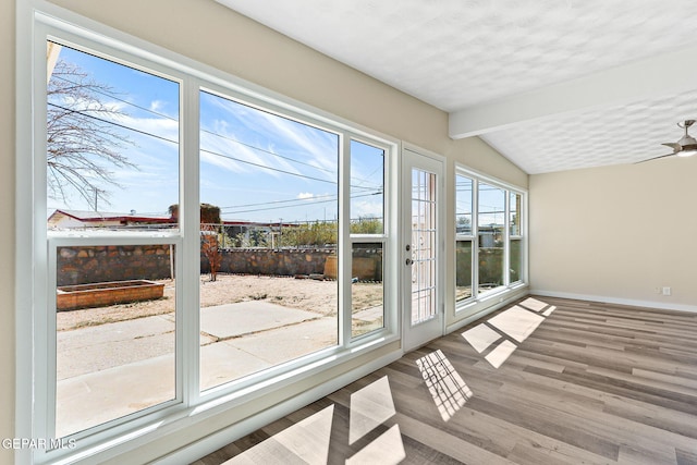 sunroom / solarium featuring a ceiling fan and lofted ceiling with beams