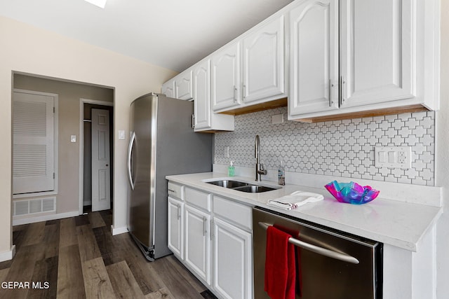 kitchen featuring stainless steel appliances, light countertops, visible vents, white cabinetry, and a sink