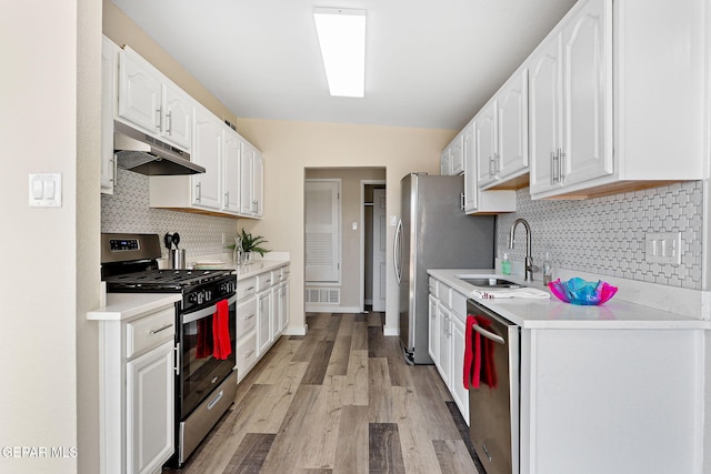 kitchen featuring visible vents, white cabinets, appliances with stainless steel finishes, under cabinet range hood, and a sink