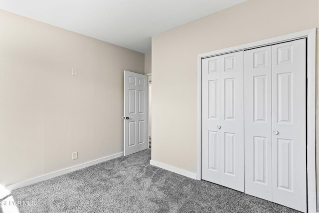 unfurnished bedroom featuring a closet, carpet, and baseboards