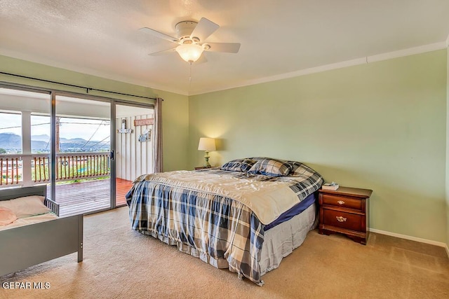 bedroom with access to exterior, a mountain view, carpet flooring, baseboards, and ceiling fan