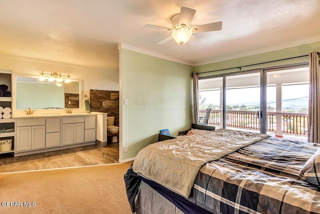 bedroom featuring a sink, light colored carpet, ensuite bath, and access to exterior