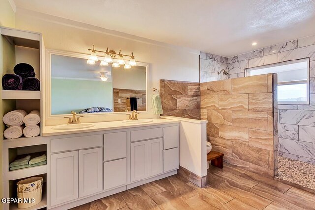 full bathroom with a sink, toilet, double vanity, and a walk in shower