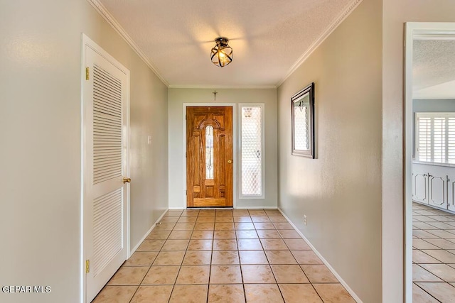 entryway with light tile patterned floors, a textured ceiling, crown molding, and baseboards