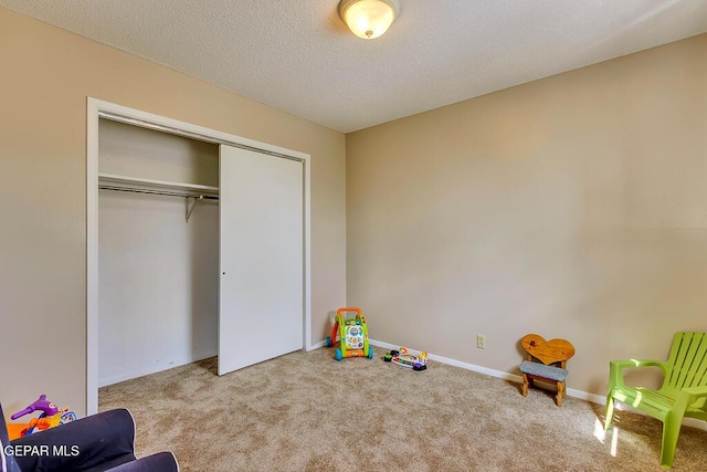 game room featuring carpet flooring, baseboards, and a textured ceiling